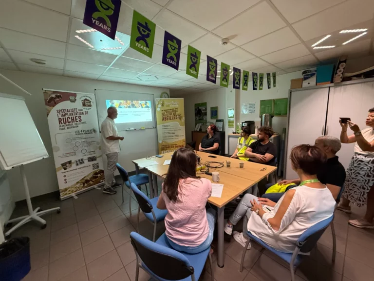 Groupe en formation autour d’une table, Jean-Luc Jouhannet devant l’écran de projection
