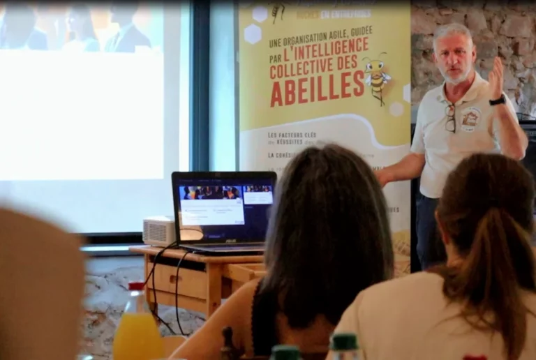 Jean-Luc Jouhannet face aux participants, devant un kakémono sur l’intelligence collective des abeilles